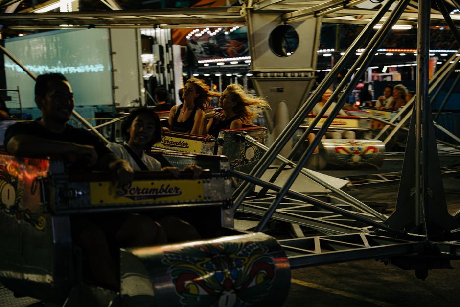 Destinos em Alta — People enjoying a thrilling ride in an amusement park at night, full of energy and fun.