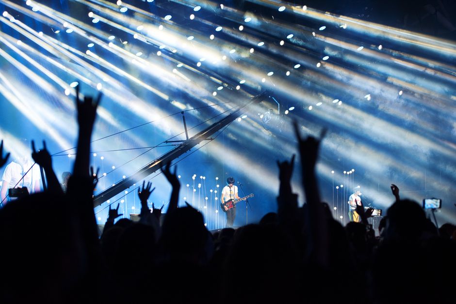 Destinos em Alta — Energetic live music performance with crowd cheering under dramatic lighting.